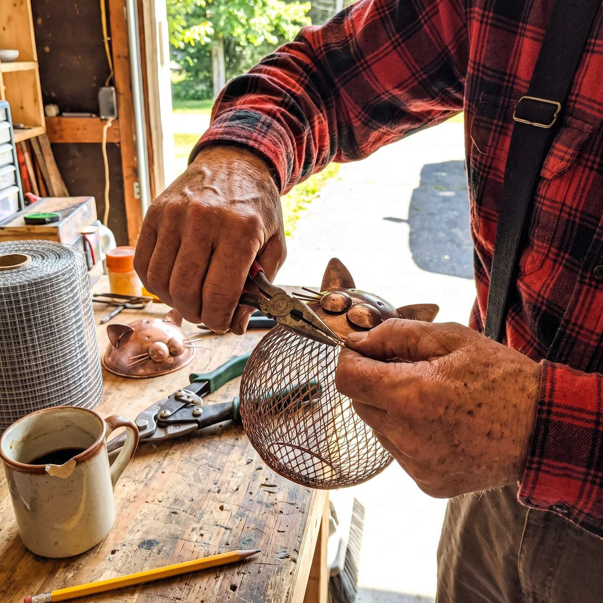 Michael shaping the mesh basket onto the copper cat head