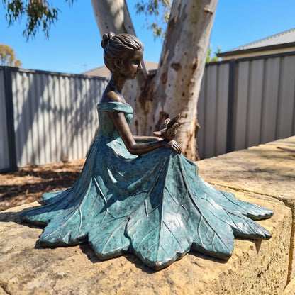 Side view of the bronze leaf-maiden bird bath on a sandstone wall