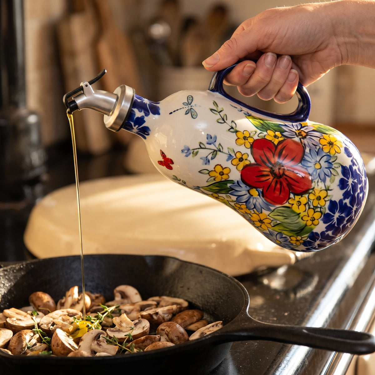 Pouring olive oil into a pan of mushrooms from the Red Poppy dispenser