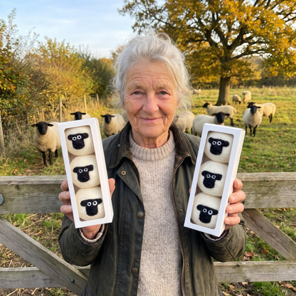 Avril Catchpole holding two boxes of her sheep dryer balls