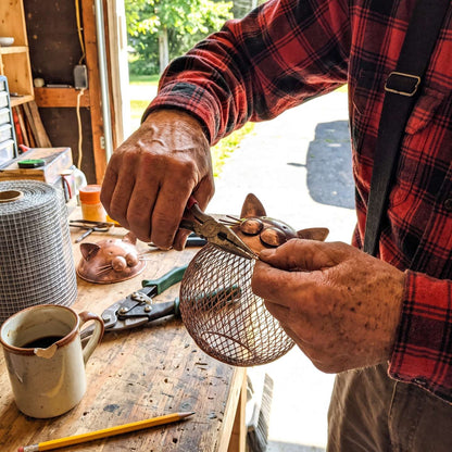 Michael shaping the mesh basket onto the copper cat head
