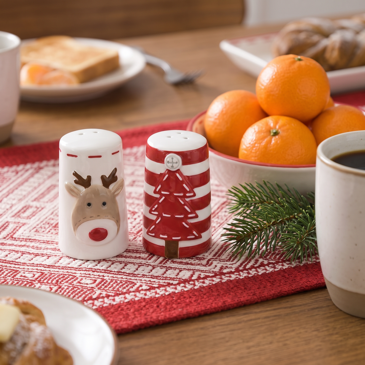 Corinne's reindeer and Christmas tree salt and pepper shakers on a red woven table runner