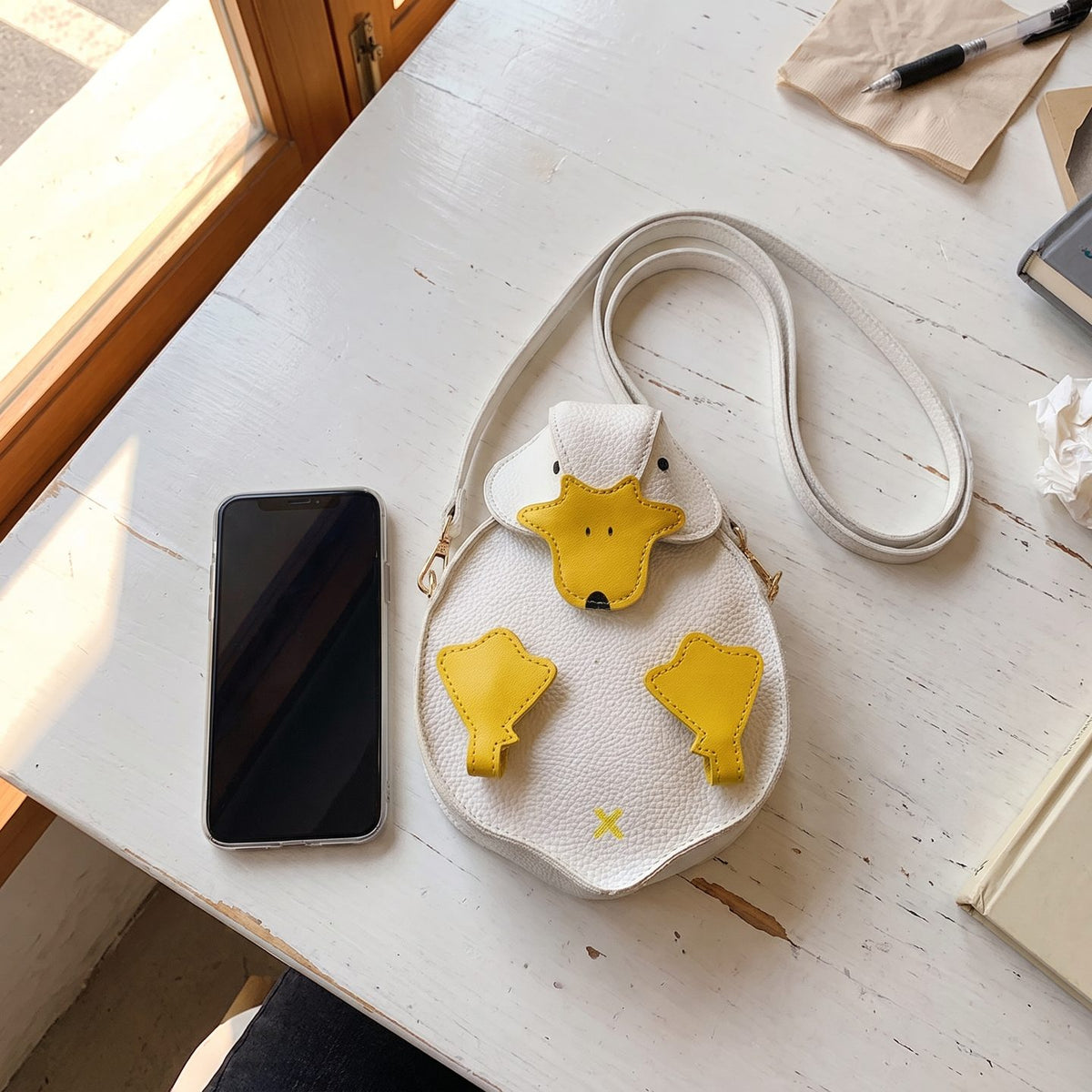 The duck bag next to a smartphone for size