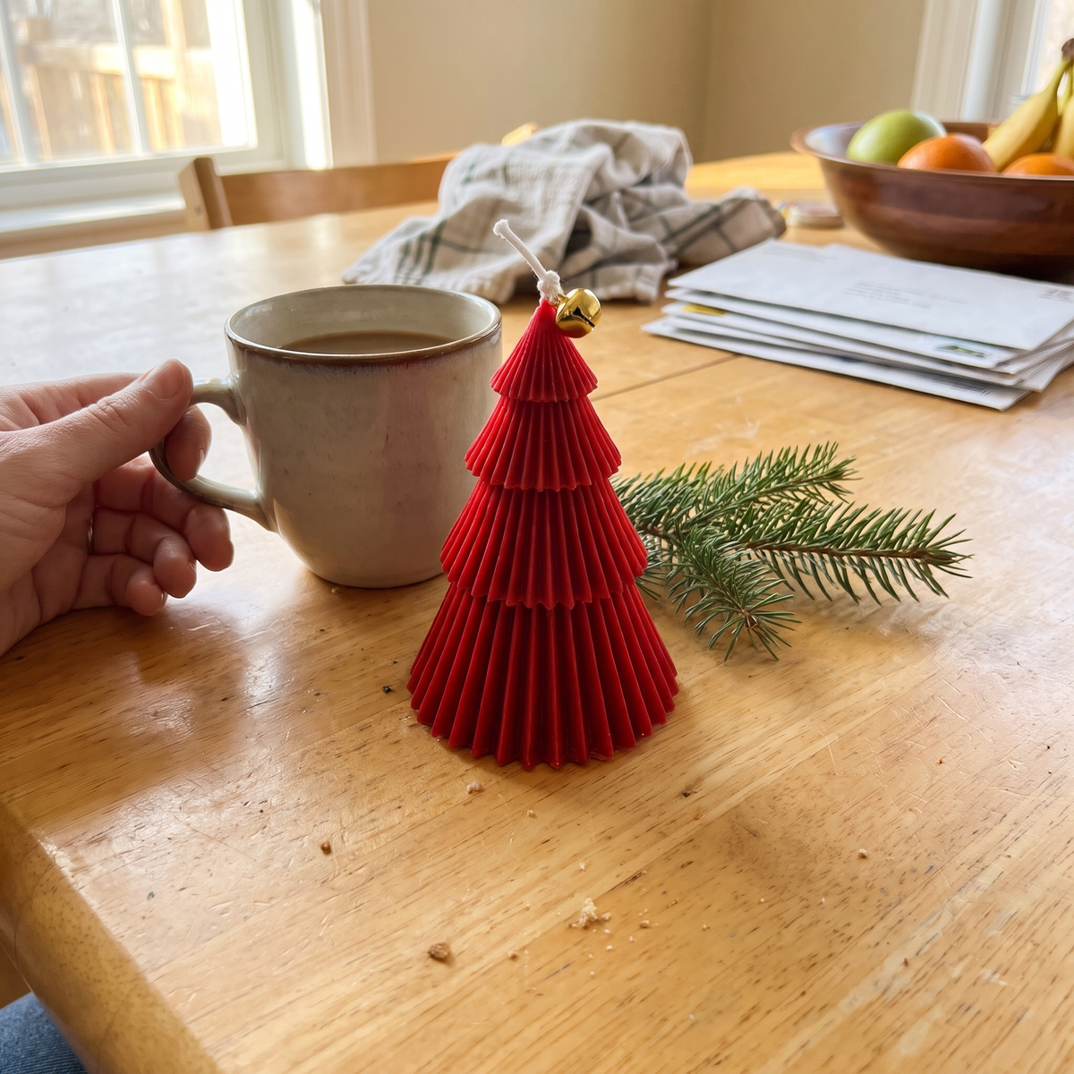 Red Fraser Tree candle by Bernadette Tibbs next to a coffee mug