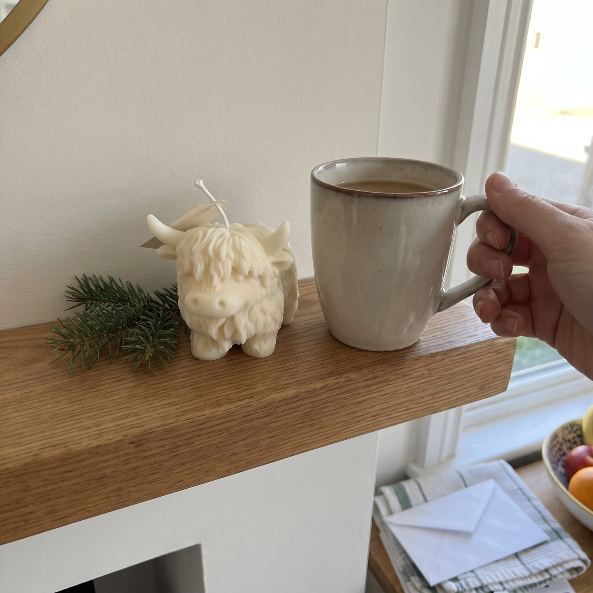 Cream Highland Cow candle on a mantel