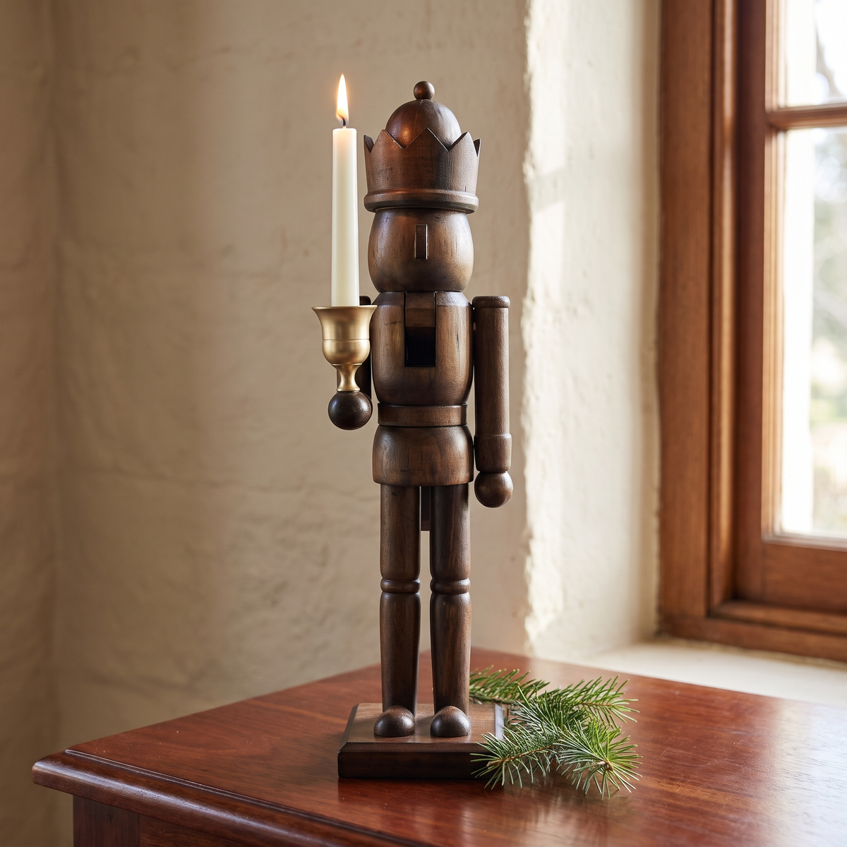 Gerhard's natural pine nutcracker king with a lit candle in its brass cup on a jarrah sideboard