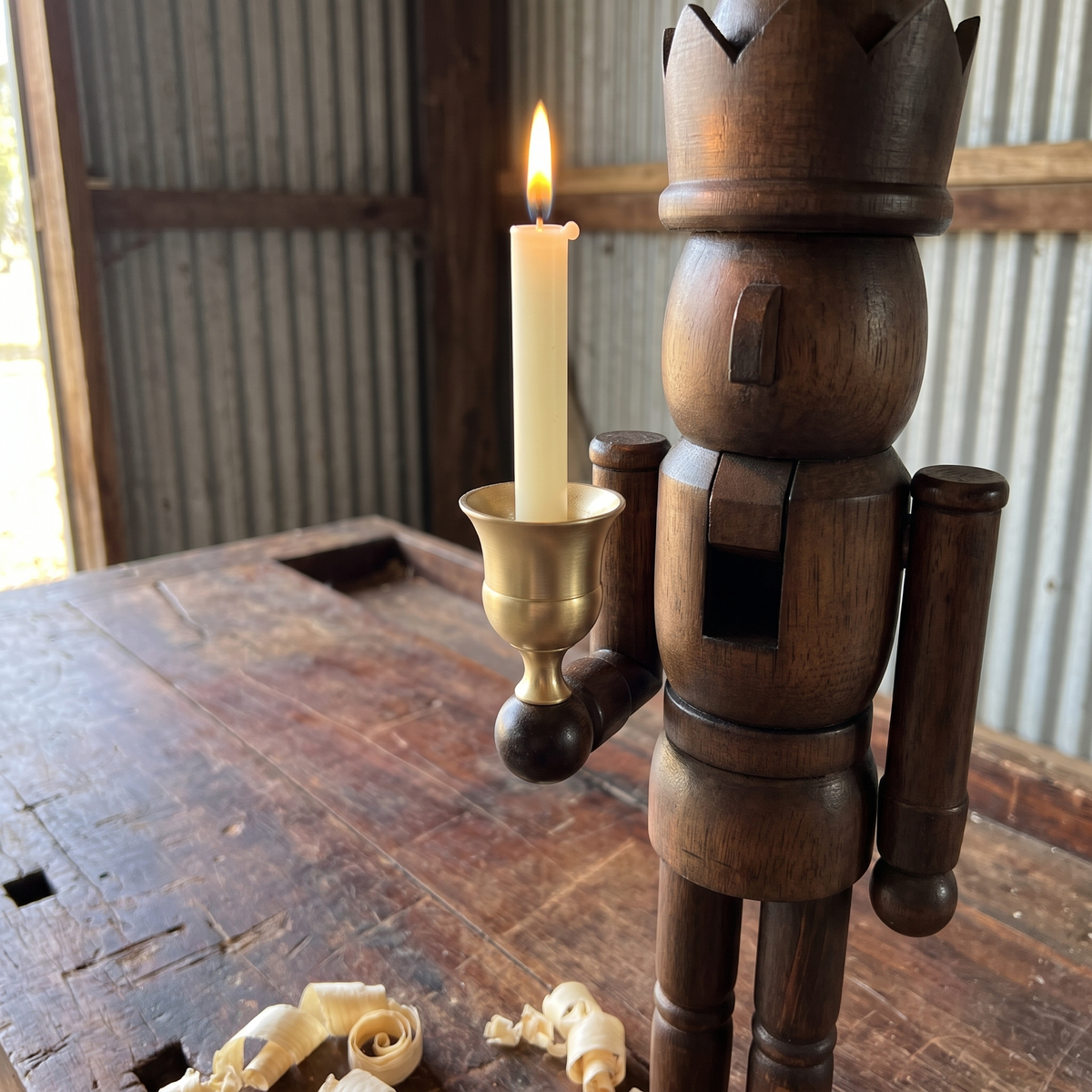 Close-up of the natural pine nutcracker's brass candle cup and walnut-stained wood grain