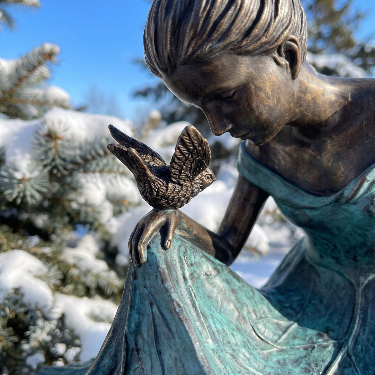 Close-up of the small bronze bird on her hand