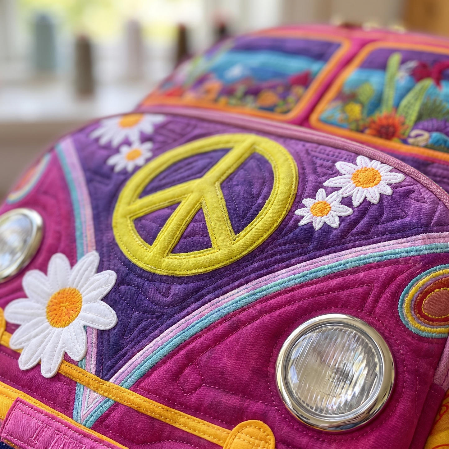 Close-up of the handquilted VW bus motif with peace sign, daisies and desert windows