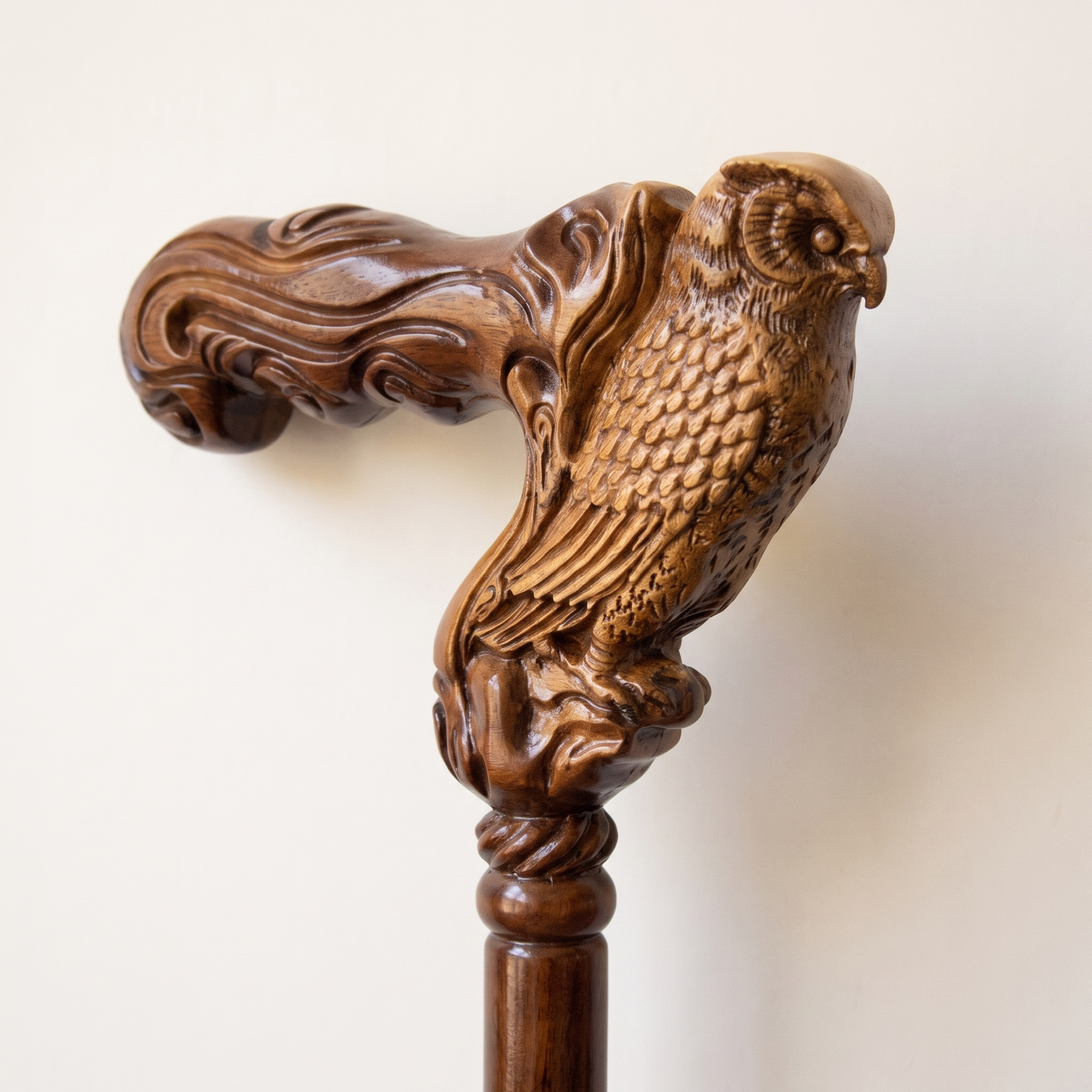 Close-up of the carved owl grip in two-tone walnut with layered feather detail