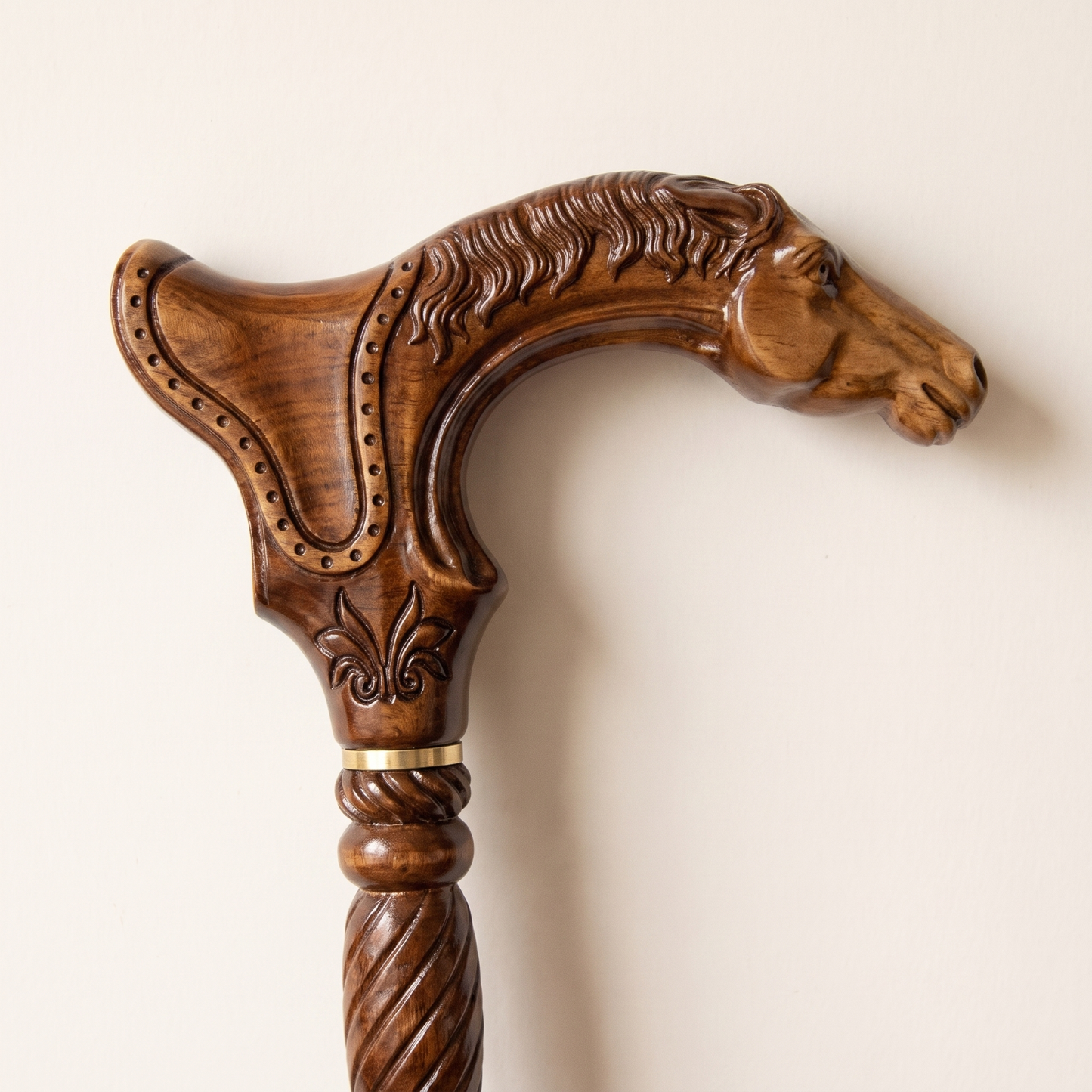 Close-up of the carved horse head derby grip with flowing mane, studded border and brass collar