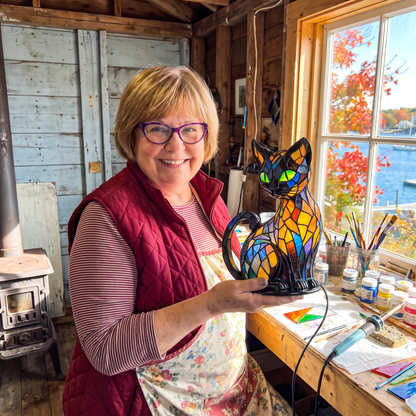 Elaine Doucette holding a Kitty Lamp in her workshop