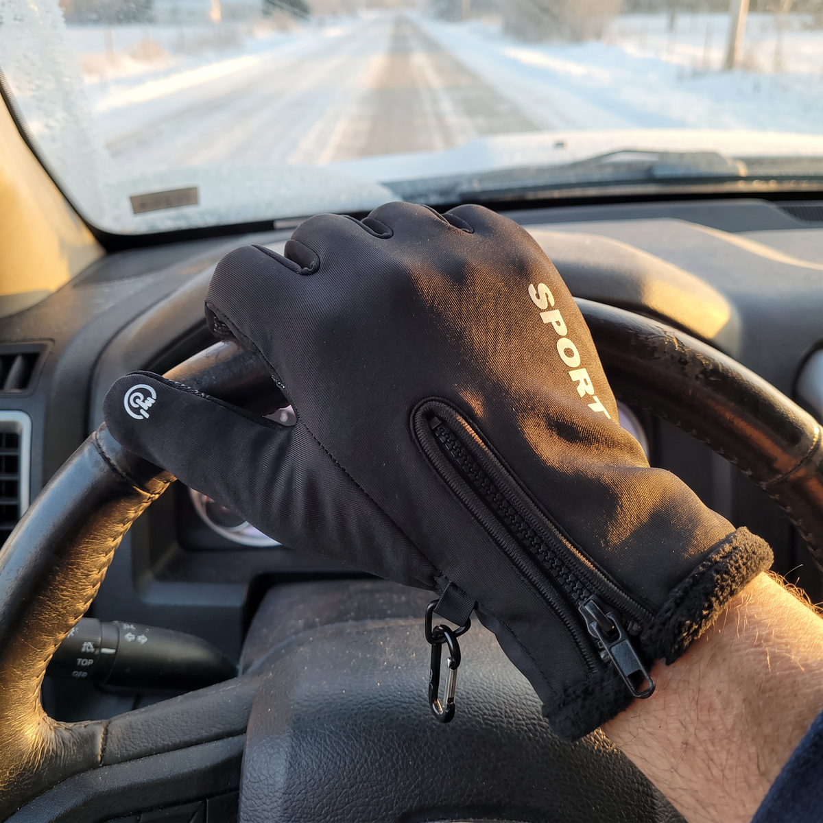 Sport Black glove gripping a steering wheel on a frosty morning