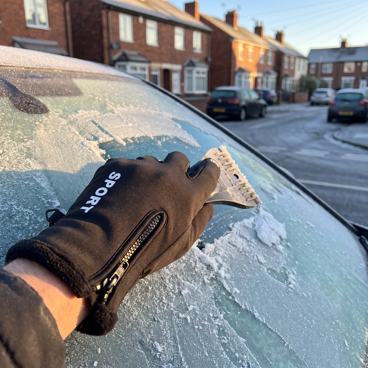 Sport Black glove scraping frost off a windscreen