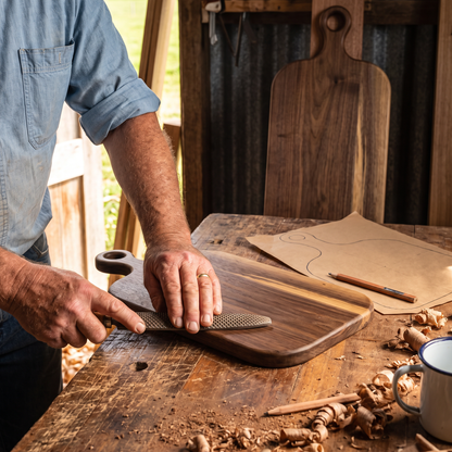 Noel shaping a board by hand with a rasp