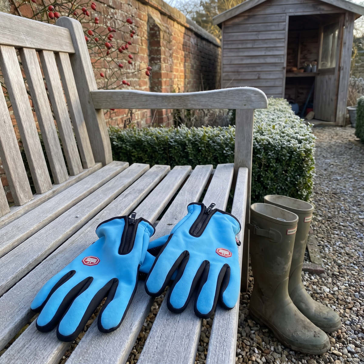 Sky Blue winter gloves on a frosty garden bench with wellies