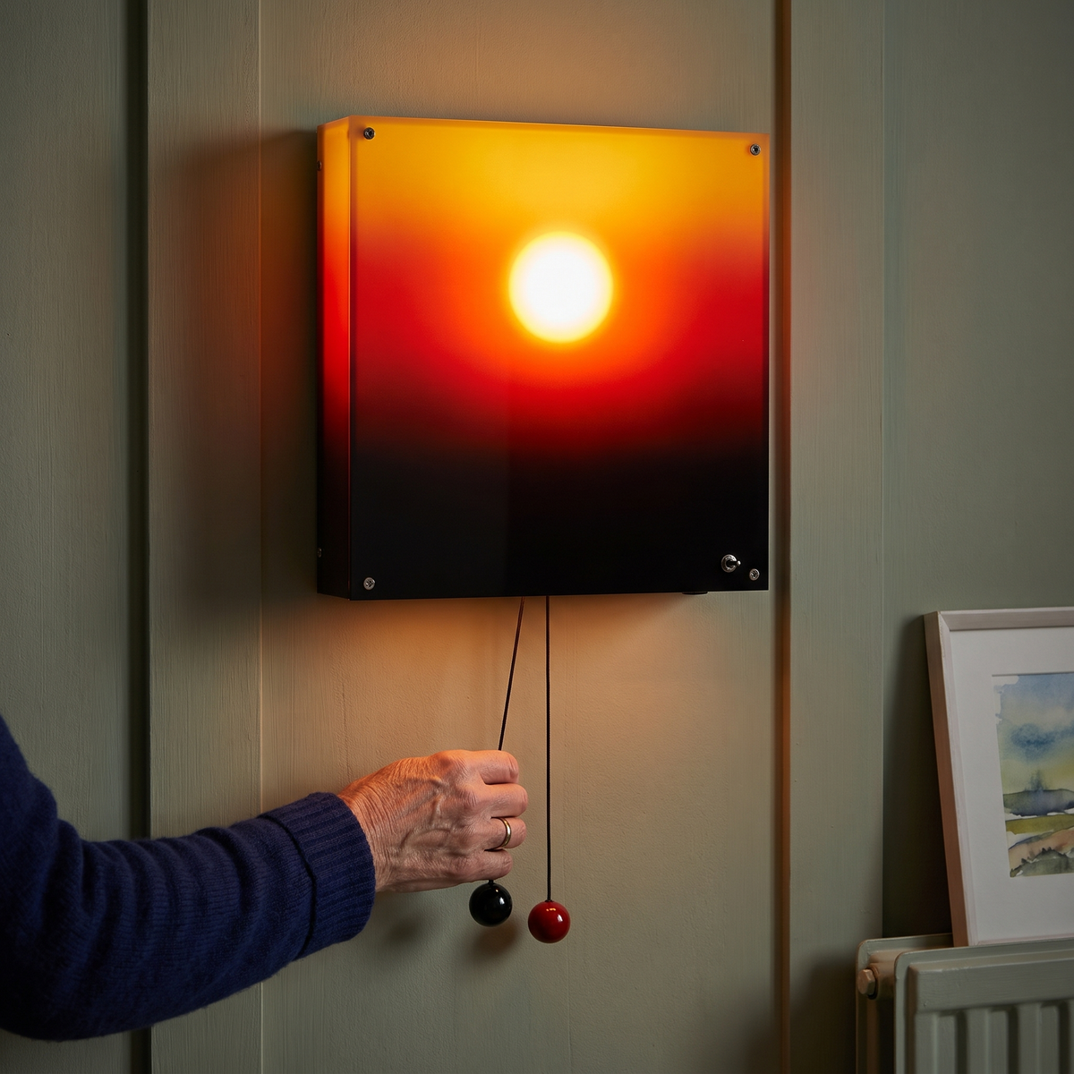 A hand pulling the red ball of the sunset lamp to lower the sun