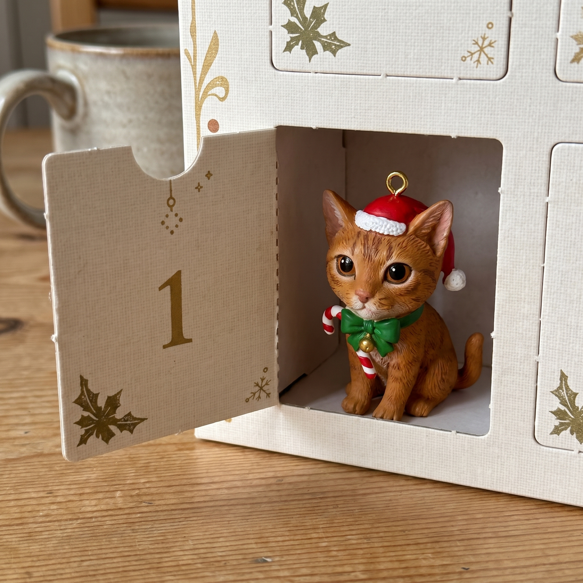 Door 1 of Imogene's Cat Advent Calendar opened, tiny hand-painted cat figurine inside