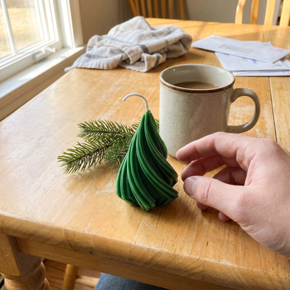 Green Spiral Tree candle next to a coffee mug
