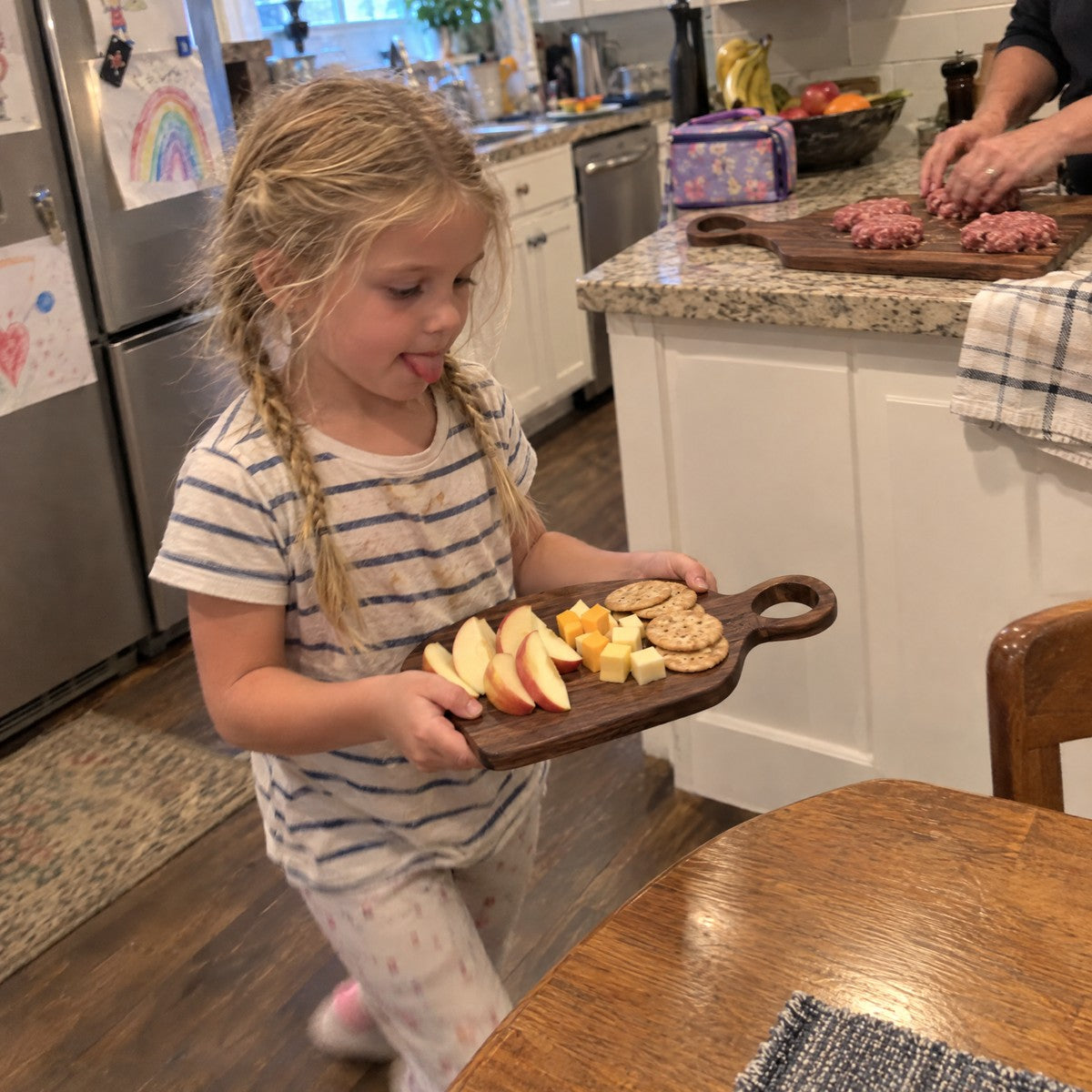 Girl carrying the small walnut board with snacks