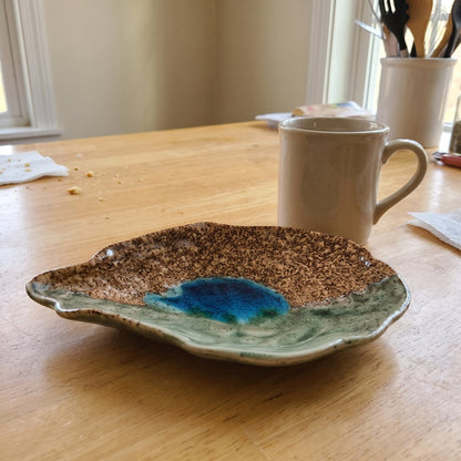 Duane's oyster shell plate in Dry Bar glaze next to a coffee mug
