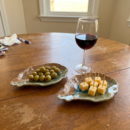A pair of Dry Bar oyster plates with olives and cheese