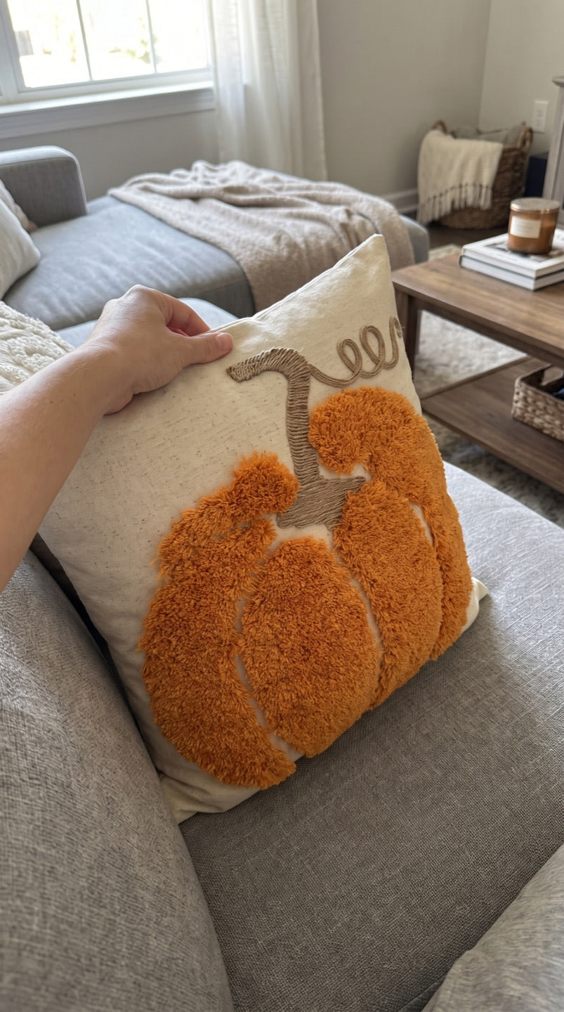 Customer photo of the orange tufted pumpkin cushion on a living room sofa