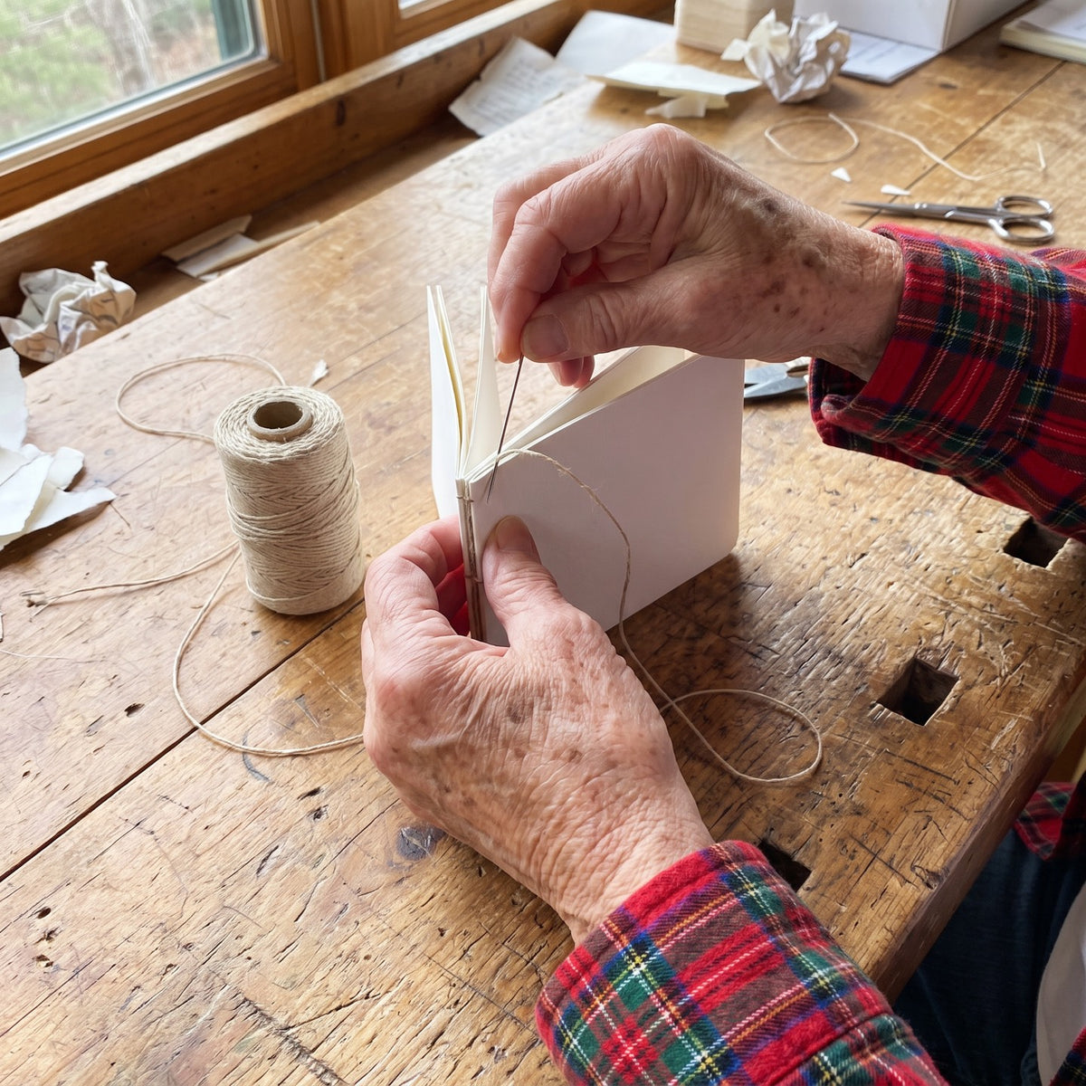 Peggy sewing a sketchbook with linen thread