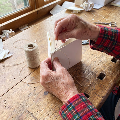 Peggy sewing a sketchbook with linen thread