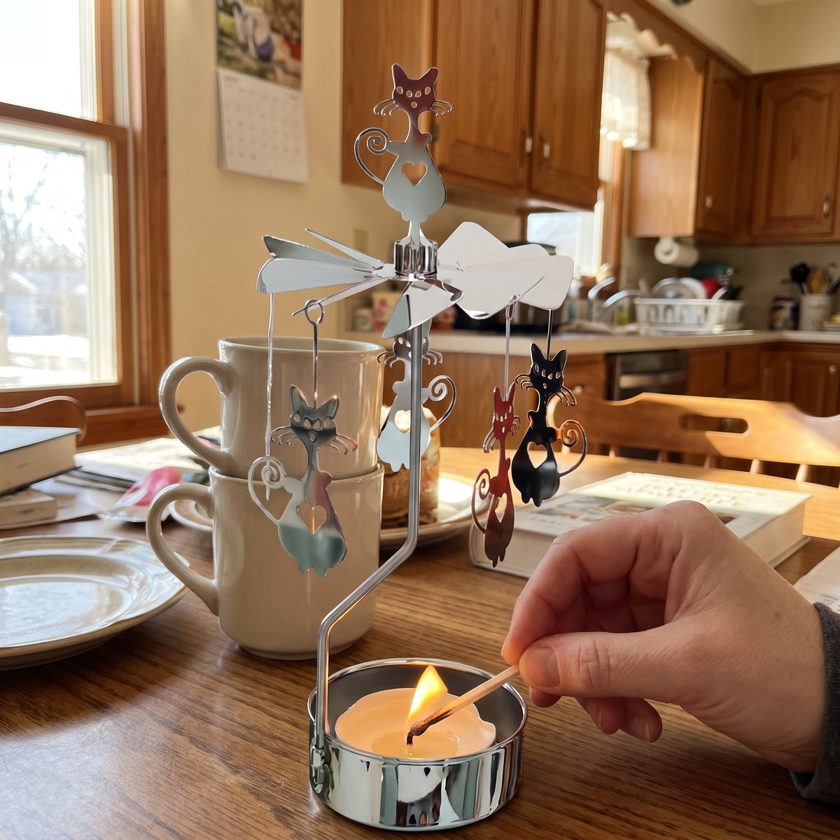 Lighting the tealight under the cat candle carousel