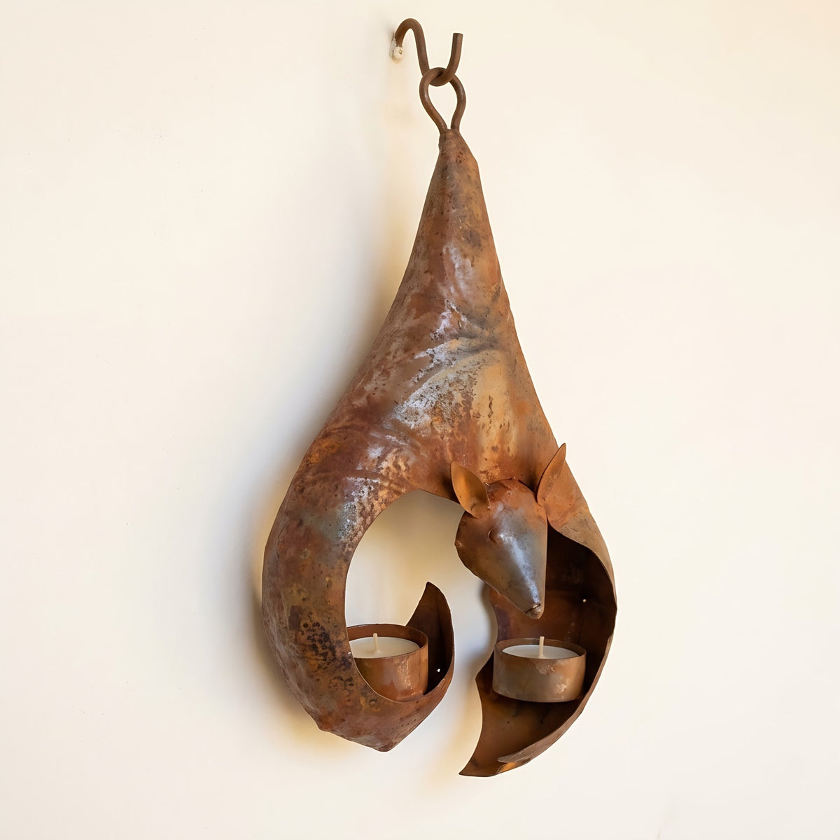 Side view: the curled iron wings and the bat's little face in profile